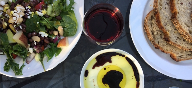 Table with salad, bread and glass of wine
